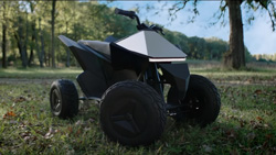 A closeup of a dark gray metal four-wheeled atv that looks similar in design to the Tesla Cybertruck.