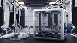A silver box (3d printer) with clear panels sits on a work bench. There are 3d models sitting next to the machine on the left including the Eiffel Tower, a dolphin, and a sports car.