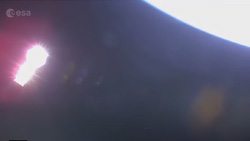 A highly reflective shiny object is shown floating in space