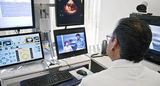 telemedicine doctor sitting in front of monitors