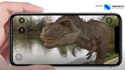 A closeup of person holding a mobile phone from the user's view. The screen shows a realistic T-Rex dinosaur with real-life lake and trees behind it