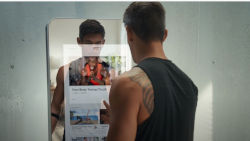 a man interacting with a full size smart mirror