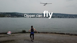A view from behind a person at the edge of a lake that is watching a plane-like drone fly away. The text reads Dipper can fly.