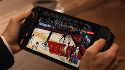 A closeup of a handheld game console show a person playing a basketball game.