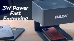 a closeup of a DAJA desktop laser engraver. The device is laser etching a design on a wooden smart phone case. The text reads 3W Power Fast Engraving