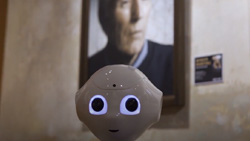 A closeup of Pepper the robot's head with a blurred background that shows a portrait on the wall.