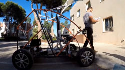 A man exits an open frame Urban Concept Vehicle from the front